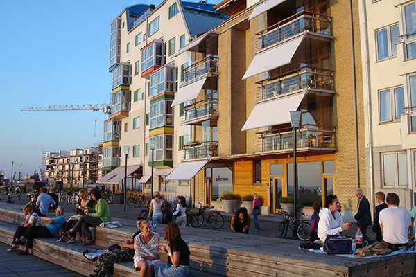 people sitting, walking and talking along a boardwalk