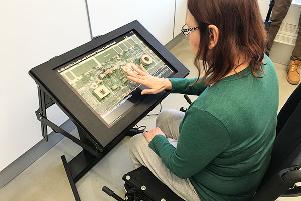 wheelchair user interacting with the smithsonian prototype touch model
