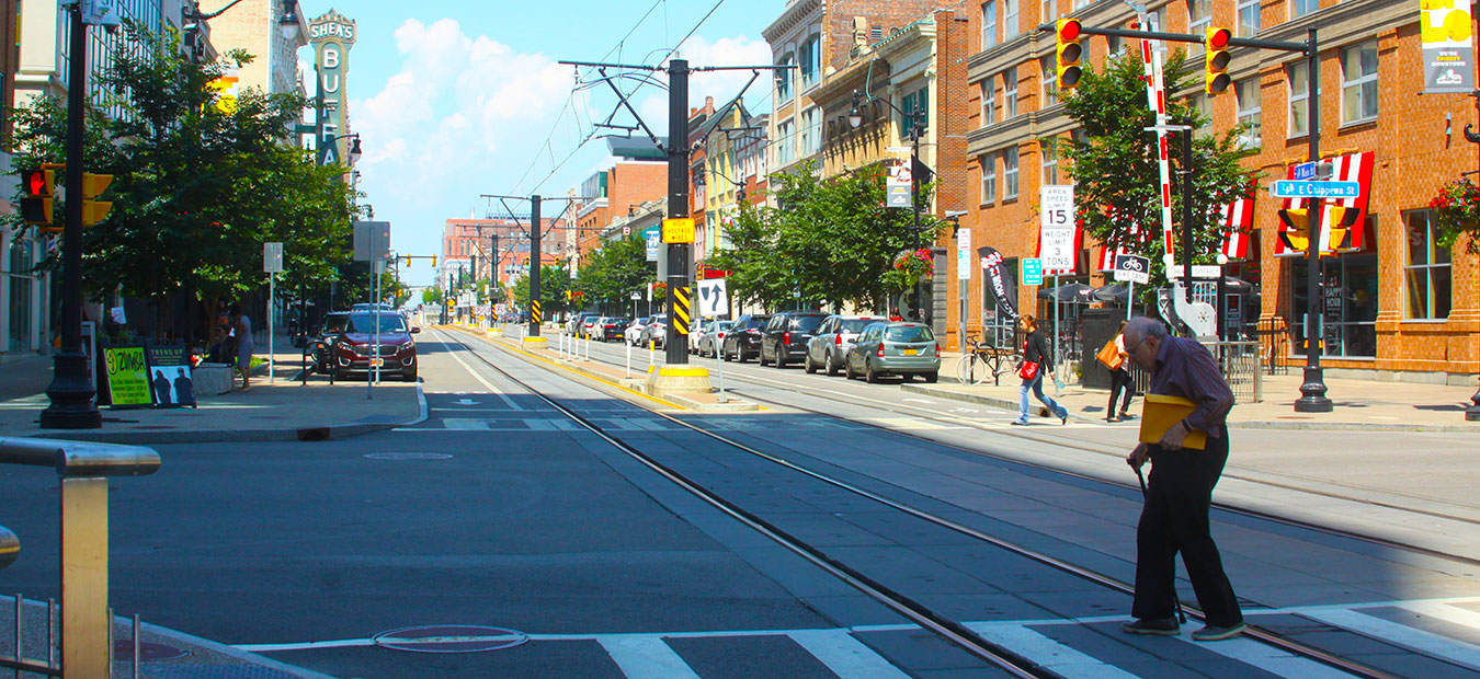 Older adult crossing intersection in Buffalo NY Chippewa and Main Street